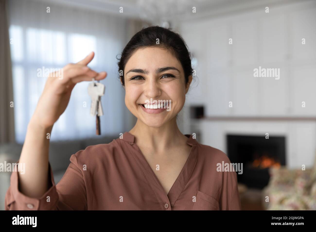 Femme indienne excitée devenir propriétaire d'une maison regarder la clé de maintien de l'appareil photo Banque D'Images