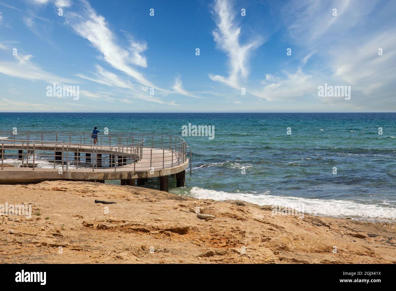 Femme seule sur la plage Ayia Napa promenade front de mer, Chypre. Banque D'Images