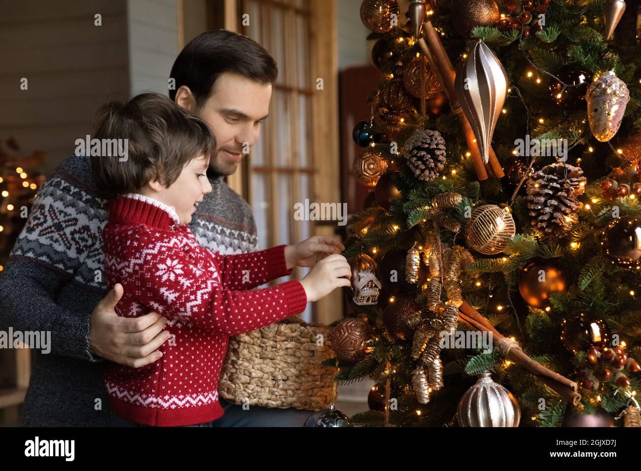 Bonne famille décorant l'arbre de Noël à la maison. Banque D'Images