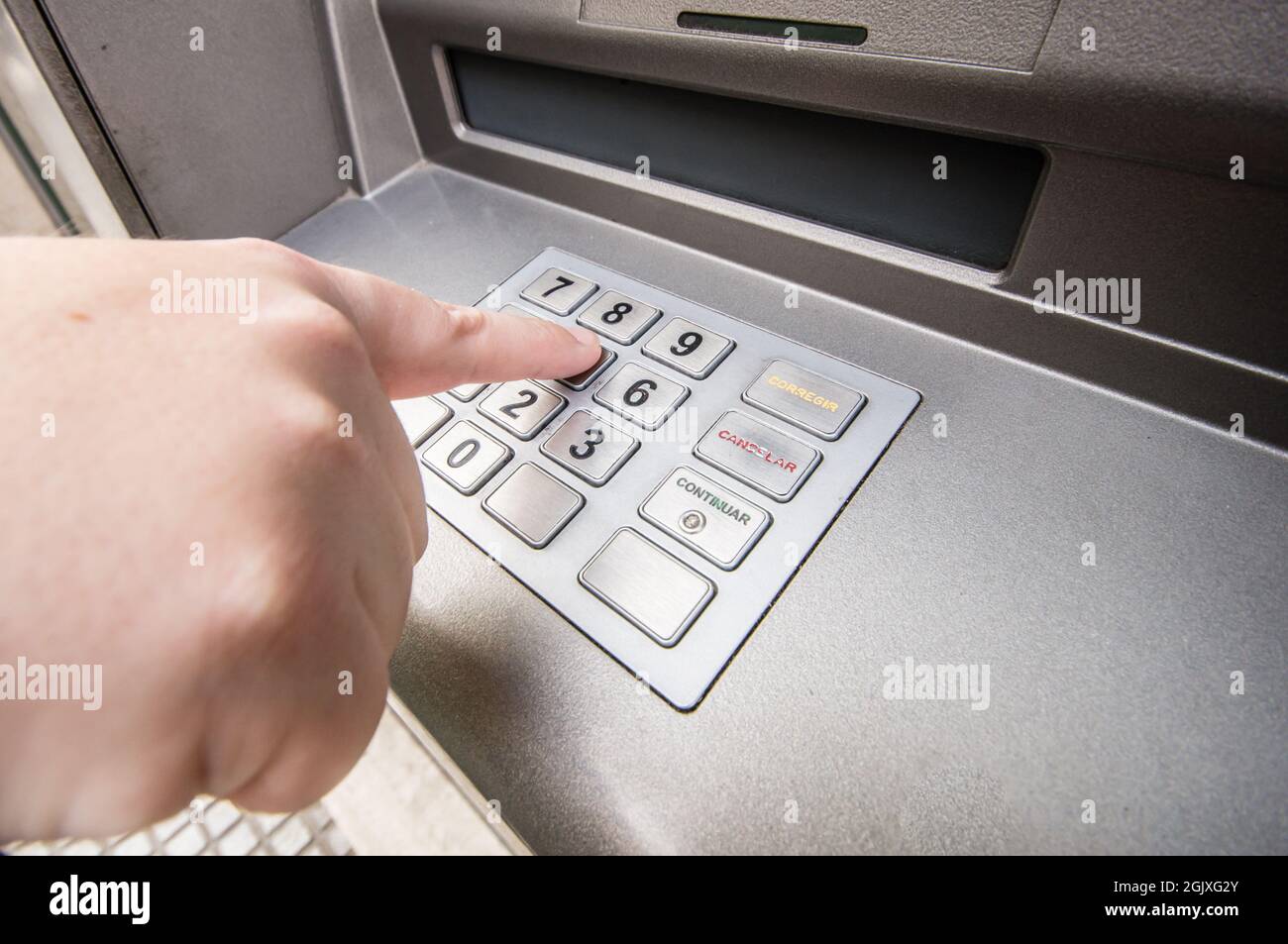 Un doigt de femme appuyant sur le numéro de mot de passe sur le distributeur  automatique de billets Photo Stock - Alamy