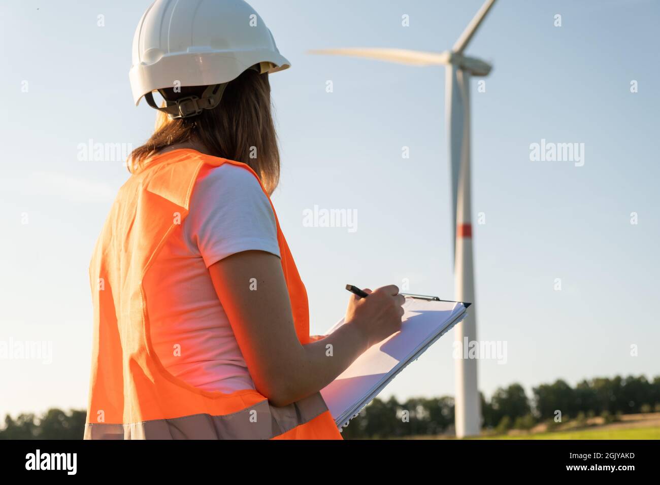 L'ingénieur de maintenance féminin contrôle le travail des éoliennes et des éoliennes. Technologie des énergies renouvelables. Production d'électricité verte. Banque D'Images