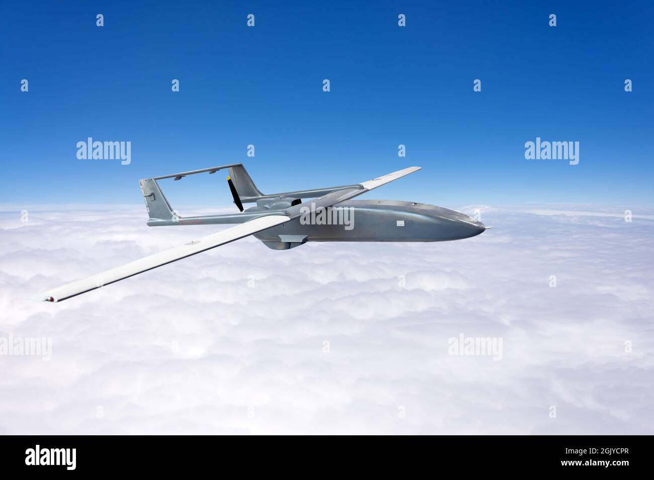 Un drone de combat survolant dans le ciel au-dessus des nuages Banque D'Images