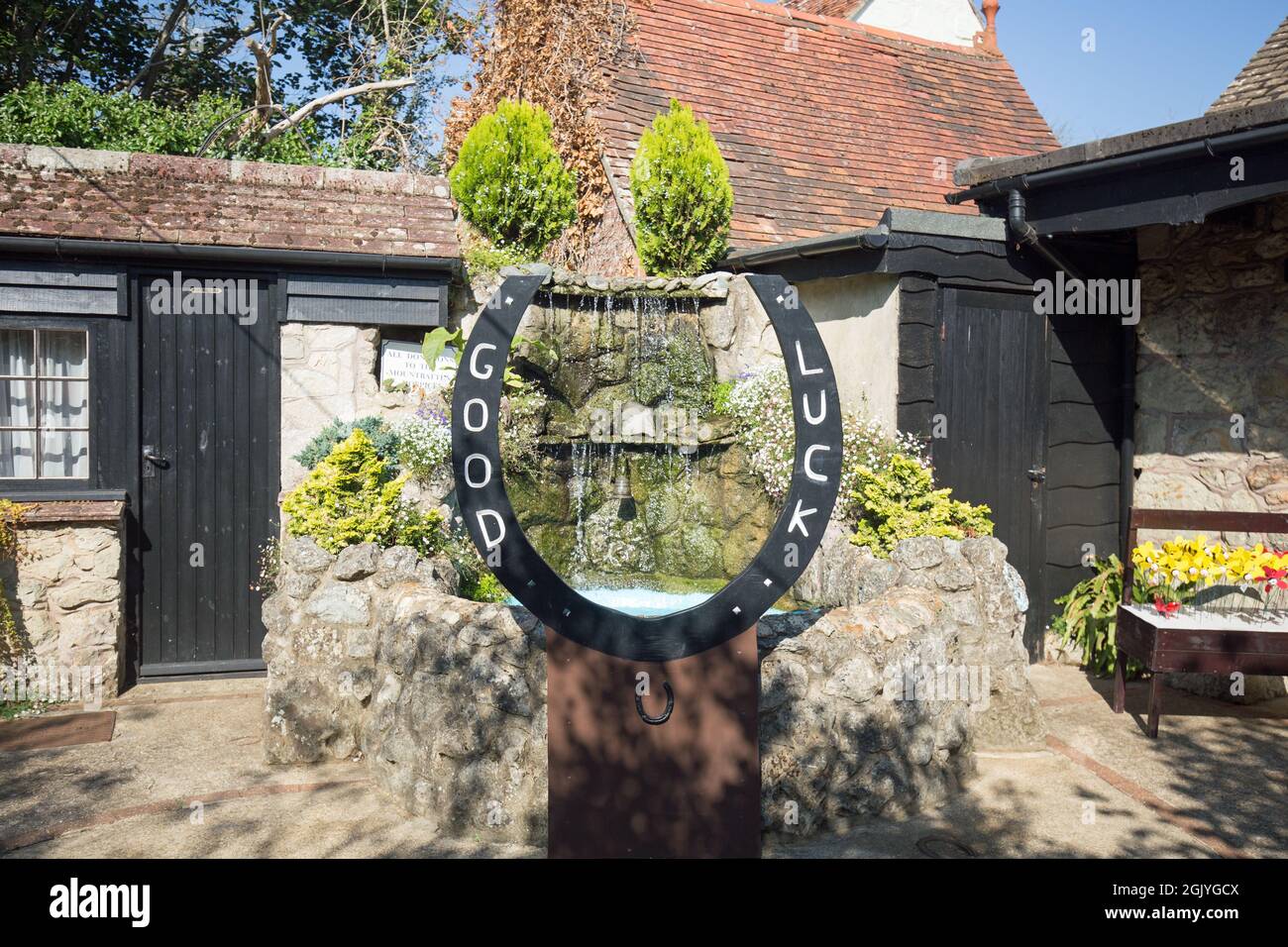 Shanklin Village, Île de Wight, 2021. Une grande chaussure de cheval bonne chance avec une petite fontaine, collectant des dons pour un hospice local. Un village pittoresque Banque D'Images
