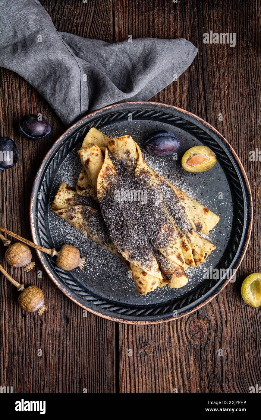 Lokse, pain plat de pommes de terre slovaque traditionnel avec confiture de prunes et remplissage de graines de pavot sur fond de bois Banque D'Images