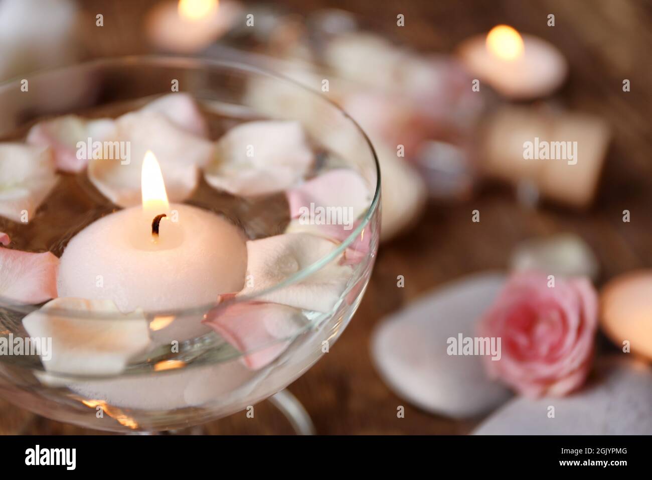 Les bougies et des pétales de rose dans le verre avec de l'eau, gros plan  Photo Stock - Alamy