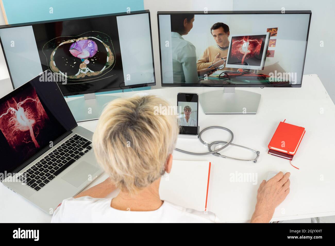 Téléconsultation entre deux médecins avec des images médicales des estomacs sur l'un des écrans. Banque D'Images