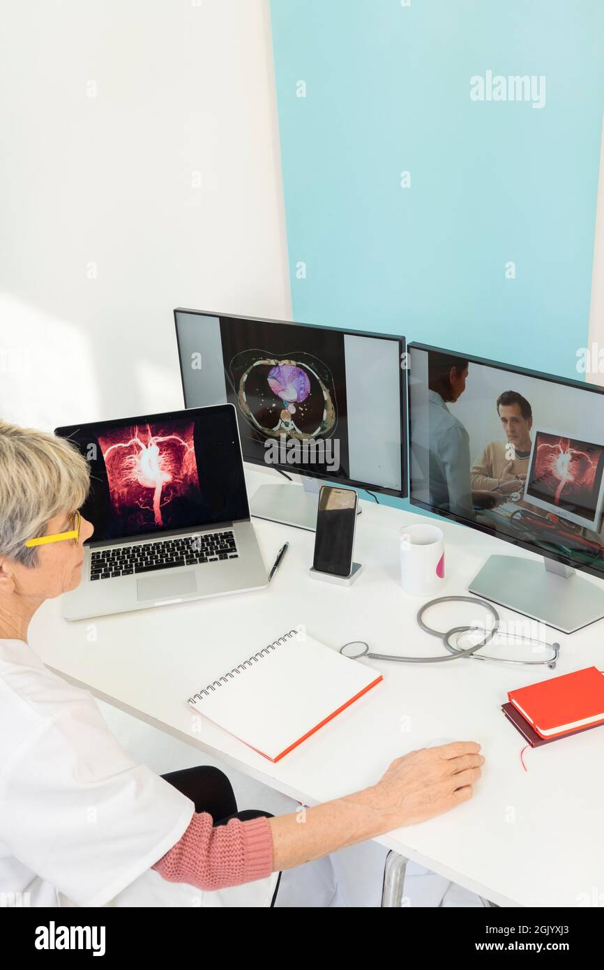 Téléconsultation entre deux médecins avec des images médicales des estomacs sur l'un des écrans. Banque D'Images