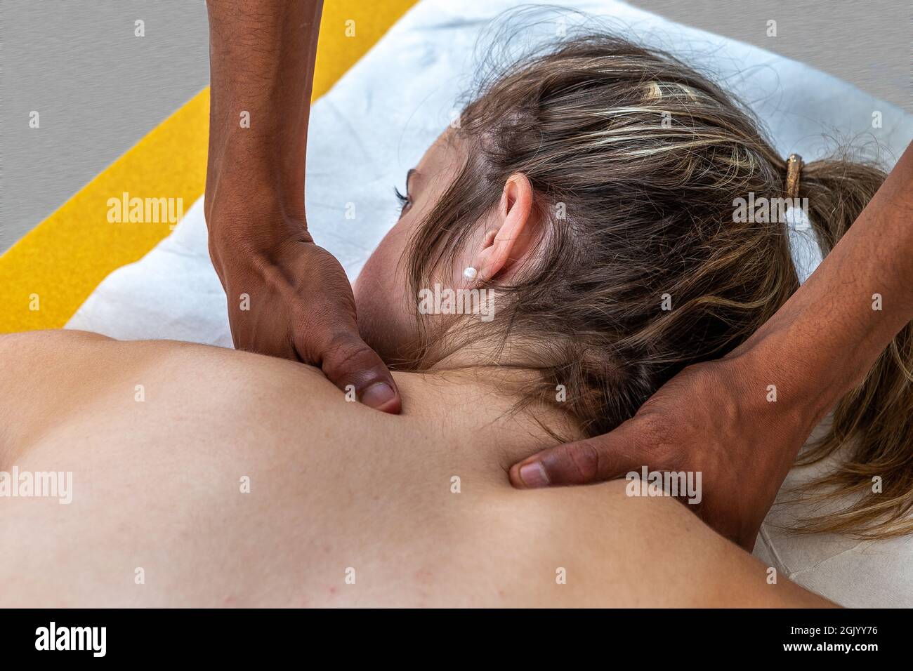 Gros plan d'un physiothérapeute manipulant une jeune femme. Une fille se couche sur un lit spa avec les mains massées Banque D'Images