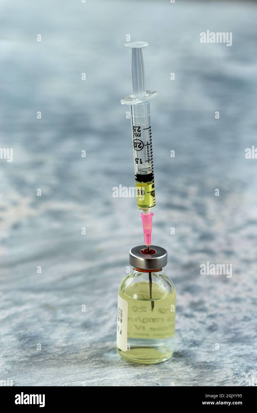 Injection du vaccin : gros plan d'une seringue prenant le vaccin en flacon dans une clinique. Banque D'Images