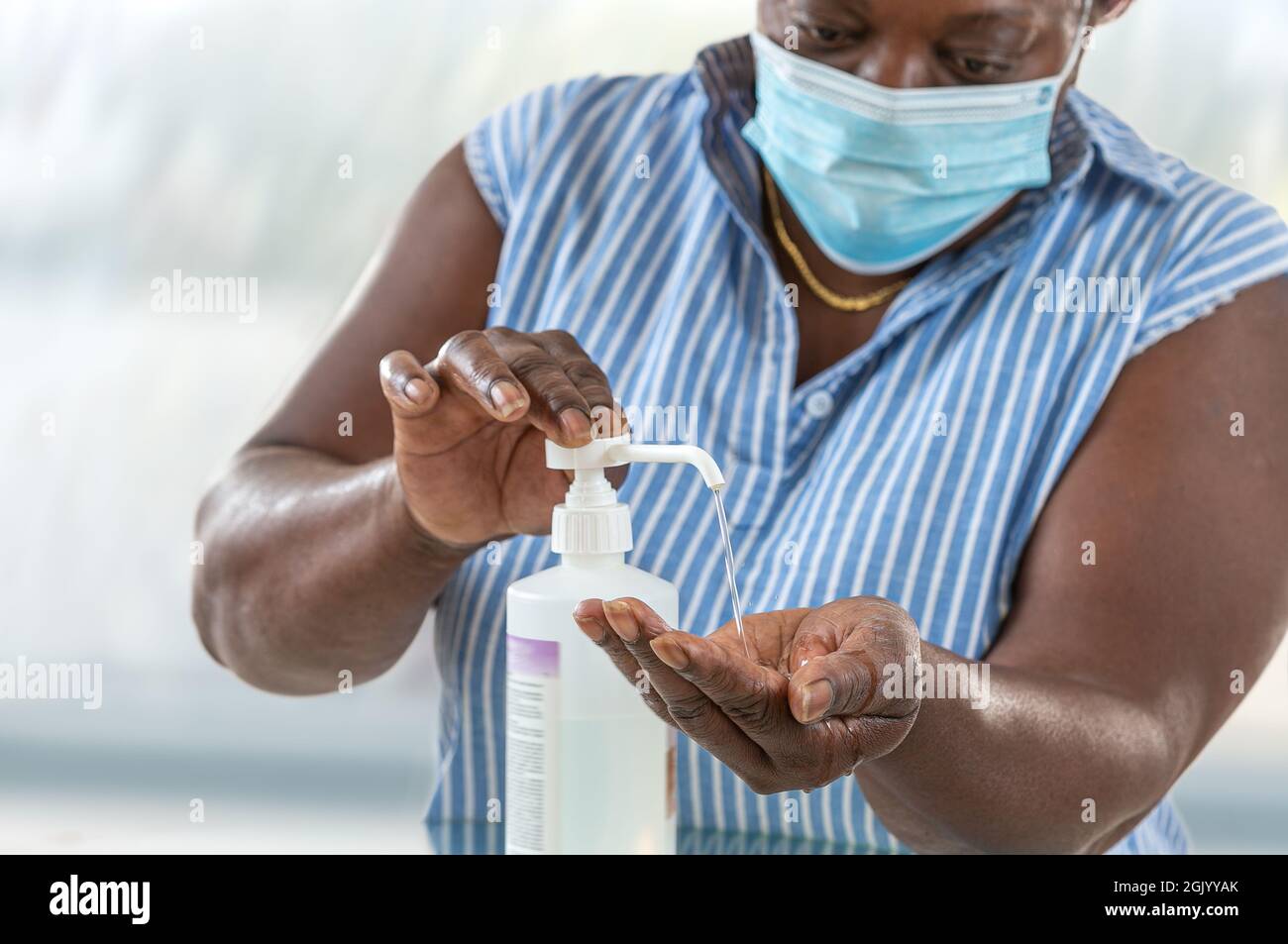 Coronavirus. Femme d'affaires travaillant à la maison portant un masque de protection pour porter un masque de protection. Se laver les mains avec du gel désinfectant. Banque D'Images