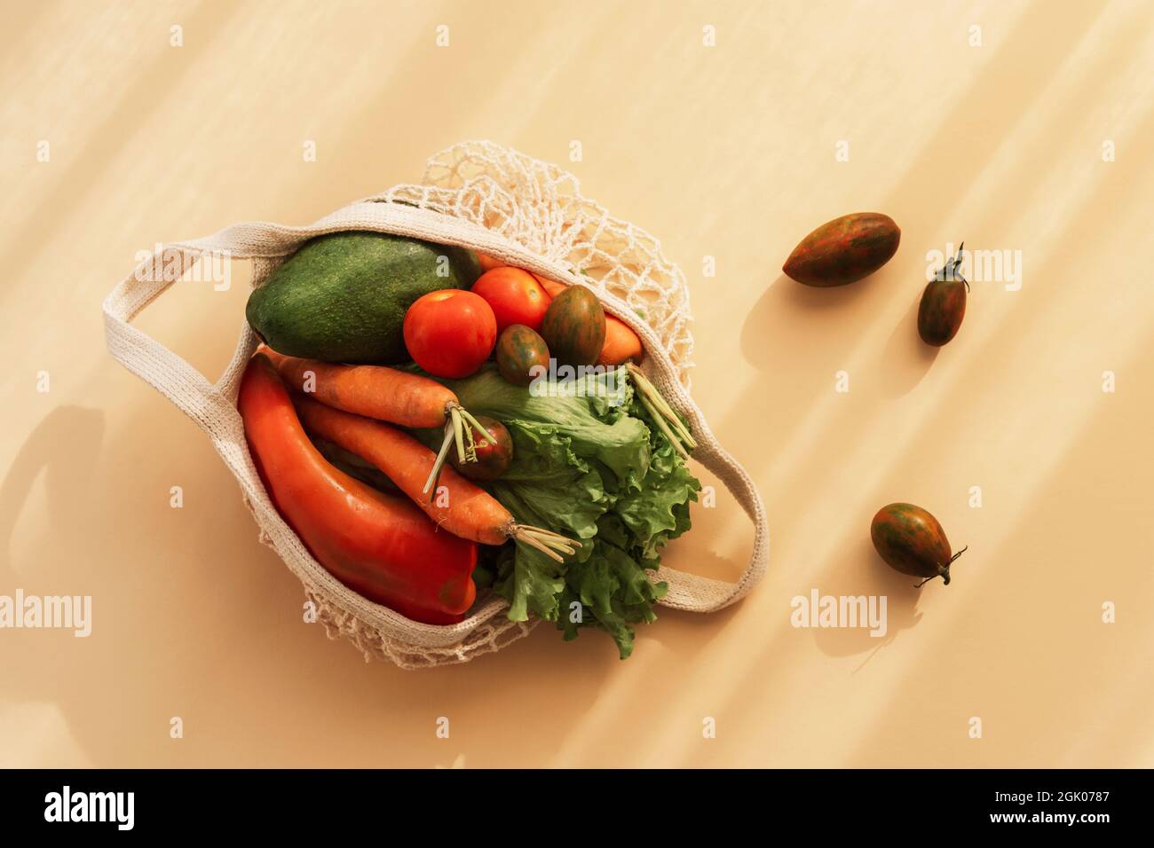 Légumes frais mûrs dans un sac à ficelle. Concept zéro déchet, nourriture saine. Vue de dessus, plan d'appartement. Banque D'Images