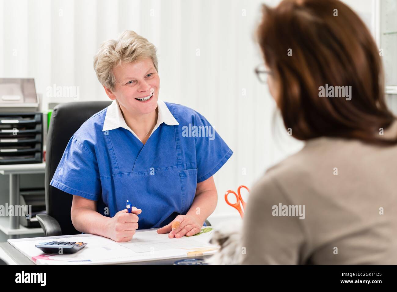 Femme vétérinaire avec propriétaire d'animal de compagnie Banque D'Images