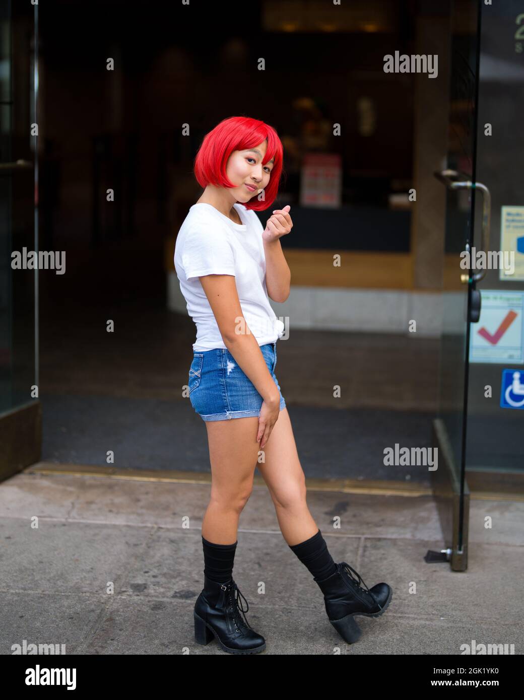 L'actrice adolescente de Cosplay asiatique devant la boutique de crèmes glacées | l'actrice de Cosplay de globules rouges devant la boutique Banque D'Images