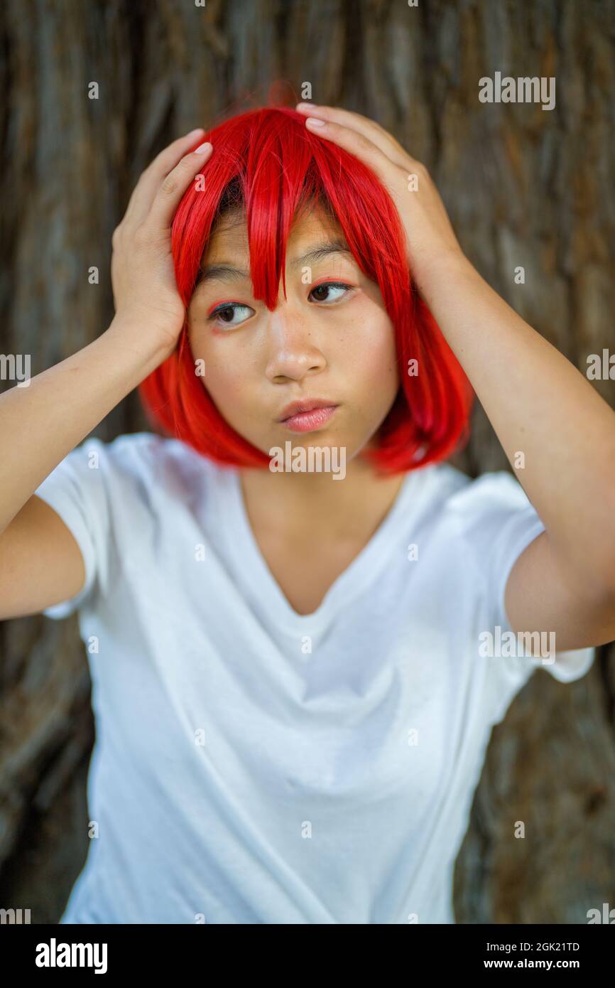 L'actrice du Cosplay de globules rouges debout avec un arbre de séquoias | fille asiatique Teen avec un cochon rouge Banque D'Images