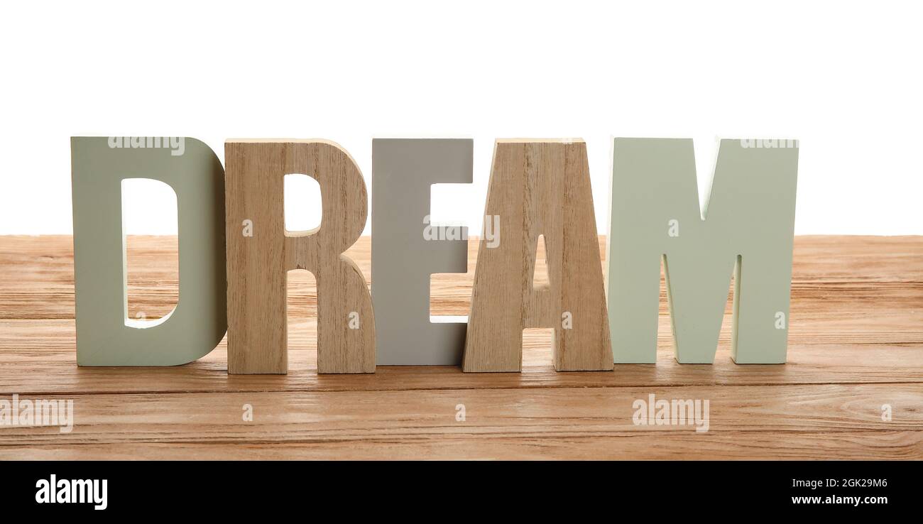 Décor élégant en forme de mot DREAM sur table sur fond blanc Banque D'Images