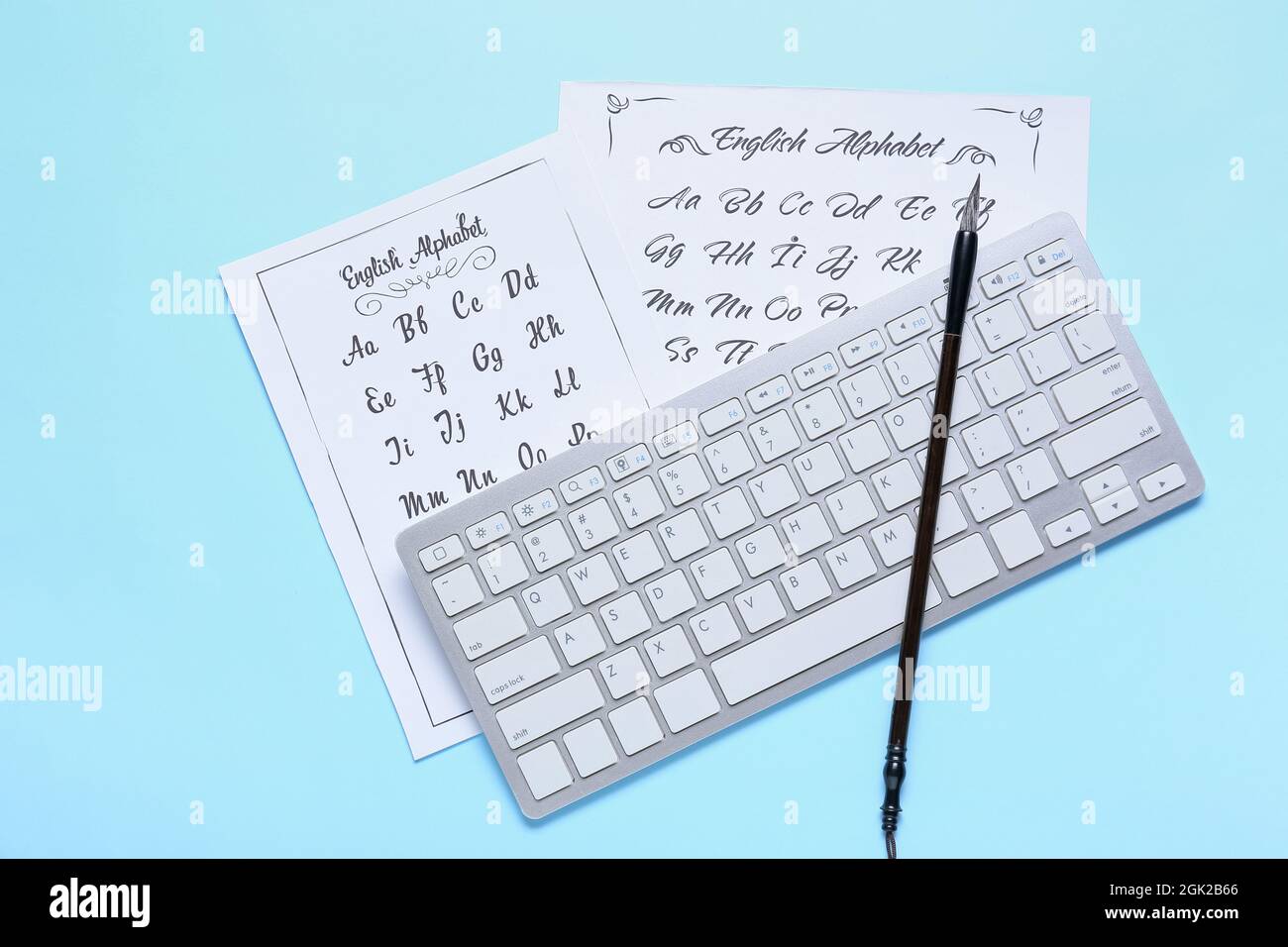 Feuilles de papier avec alphabet, clavier d'ordinateur et pinceau sur fond  bleu Photo Stock - Alamy