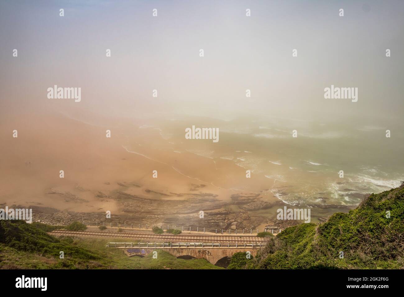 Vue sur la plage de Kaaiman's River Beach avec pont ferroviaire pendant la matinée brumeux à Wilderness dans la route des jardins de Western Cape, Afrique du Sud. Banque D'Images