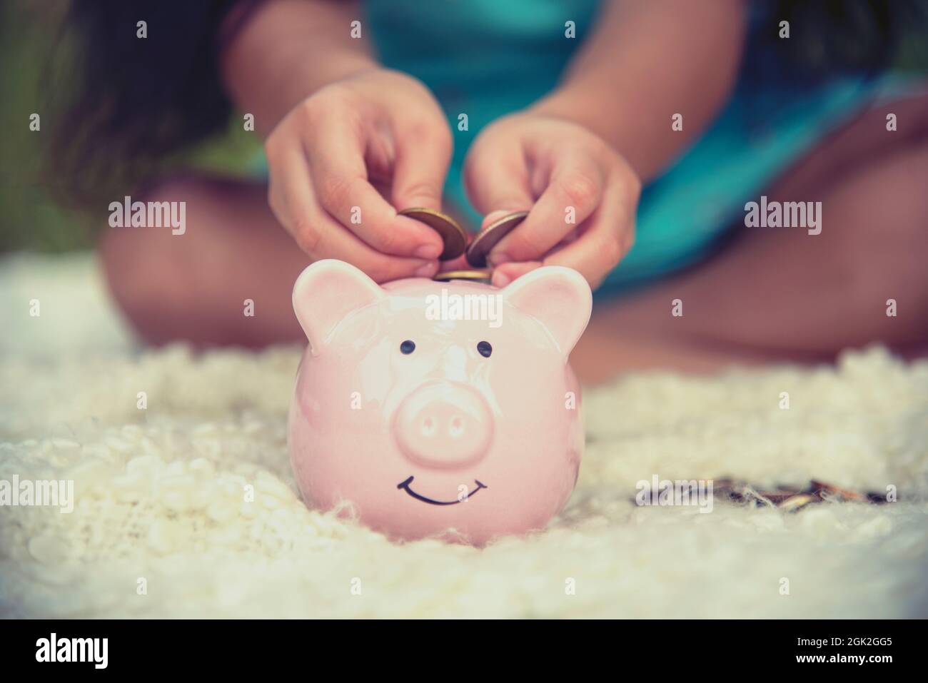 Adorables enfants économisant des pièces de monnaie dans la banque de porc. Bon petit investissement permettant d'économiser de l'argent pour le bonheur futur. Les filles souriant avec le visage heureux Banque D'Images