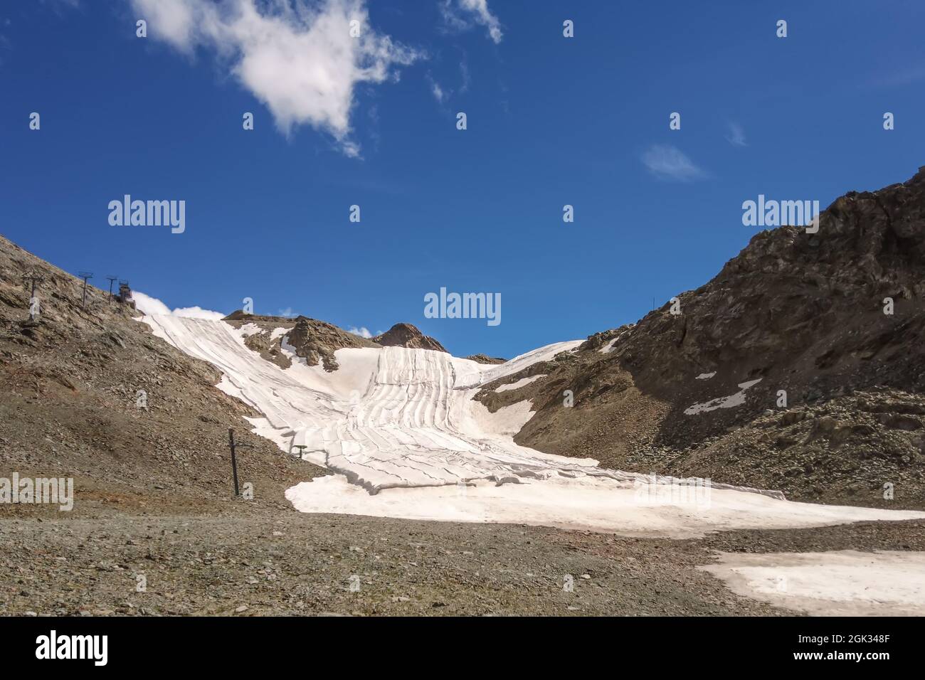 Champ de neige d'été sur les Alpes suisses recouvert d'un tissu qui le protège de la chaleur Banque D'Images