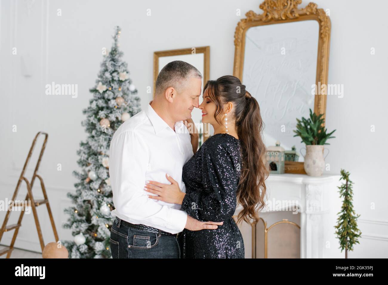 Un couple amoureux rencontre le nouvel an et célèbre Noël, embrassant, riant à l'arbre de Noël Banque D'Images
