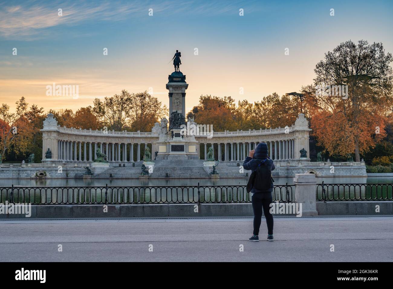 Madrid Espagne, horizon de la ville au lever du soleil au parc El Retiro avec femme touriste et saison de feuillage d'automne Banque D'Images