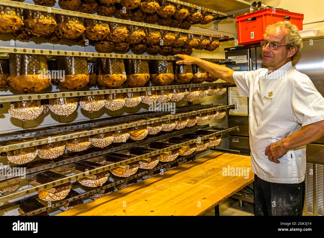 Pour éviter que le magnifique dôme ne s'effondre, les panettone sont suspendus à l'envers pour refroidir immédiatement après la cuisson. Production de panettone dans la Pasticceria Marnin à Locarno, Suisse. Circolo di Locarno, Suisse Banque D'Images