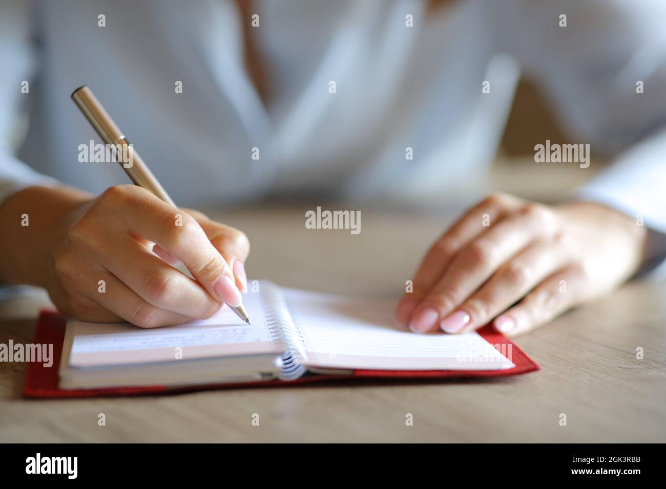 Gros plan d'une femme mains écriture manuscrite sur l'ordre du jour papier Banque D'Images