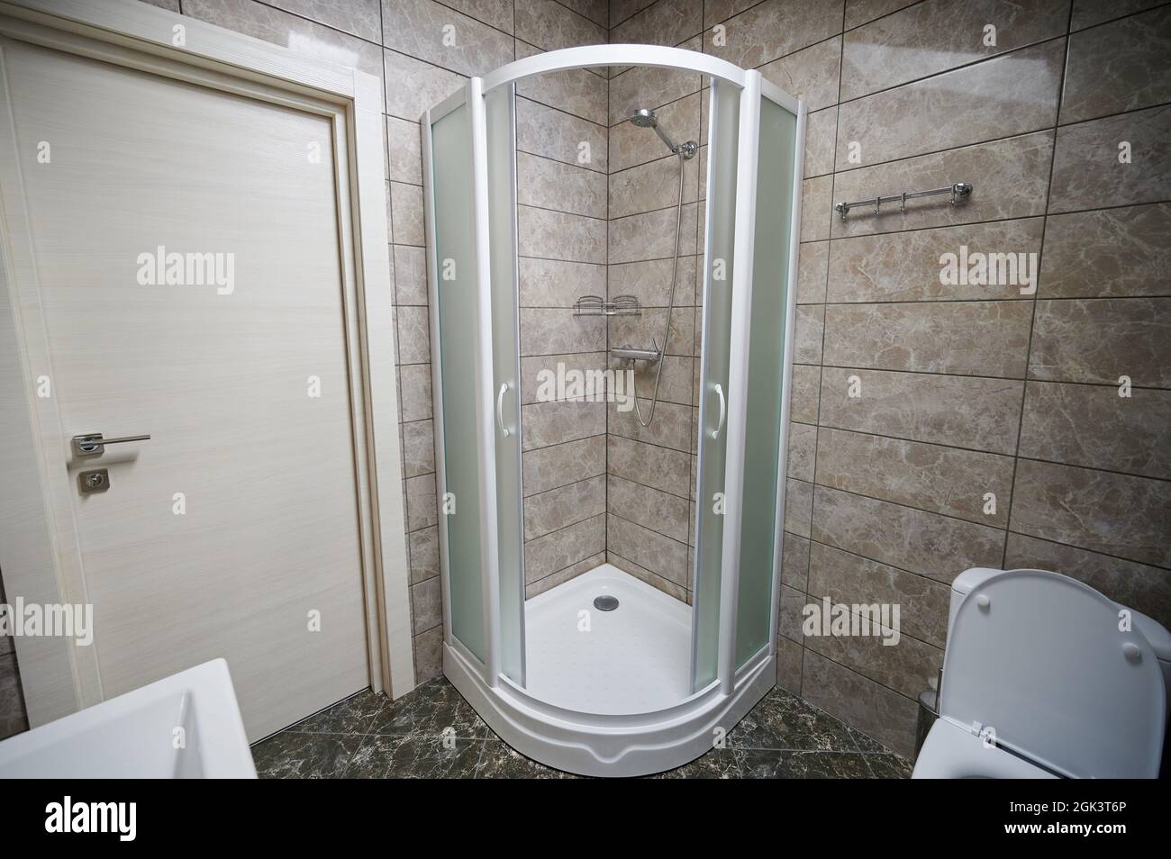 Salle de bains avec cabinet de douche et toilettes dans un intérieur brun moderne Banque D'Images
