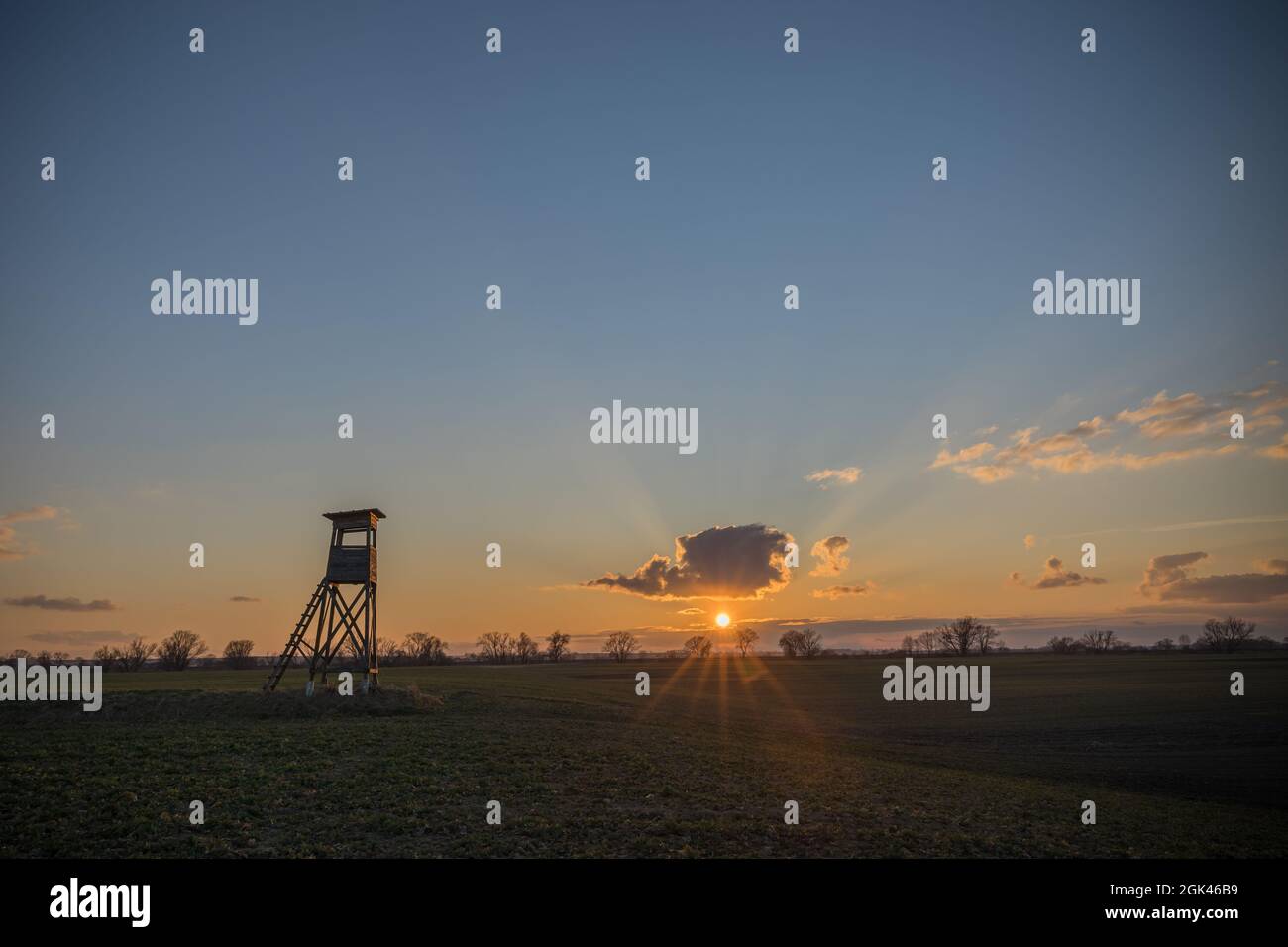 le soleil couchant, ciel coloré, silhouette d'une tourelle de chasse Banque D'Images