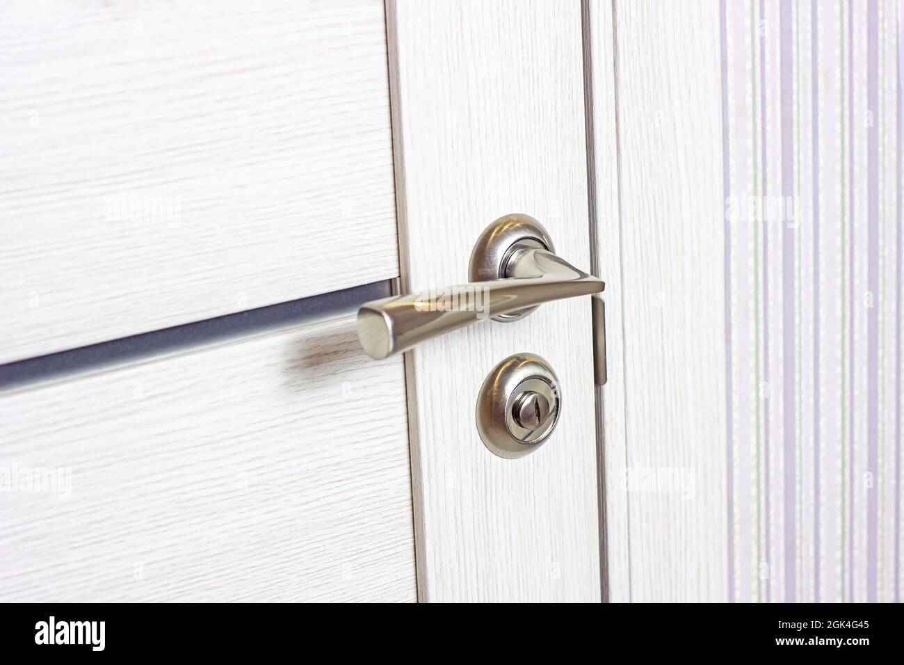 Porte en bois blanche fermée avec poignée de porte moderne en métal dans la maison. Banque D'Images
