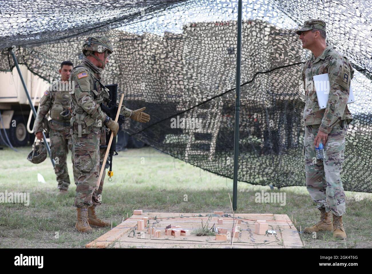 Le capitaine de l'armée américaine Kayla Gonzales, officier de plans affecté à la 36e Brigade de soutien, 36e Division d'infanterie, Garde nationale de l'armée du Texas, fournit un exposé sur le concept des opérations au Brig de l'armée américaine. Le général Bryan Howay, commandant adjoint, première division de l'Armée de terre est, lors de sa visite au Northern Strike 21-2 au Camp Grayling joint maniement Training Centre, le 1er août 2021. La grève du Nord, organisée par la Garde nationale du Michigan, fournit une brigade de soutien et soutient les commandants de bataillon avec un exercice de préparation qui met l'accent sur l'interaction du personnel, la planification et la prise de décision permettant aux unités t. Banque D'Images