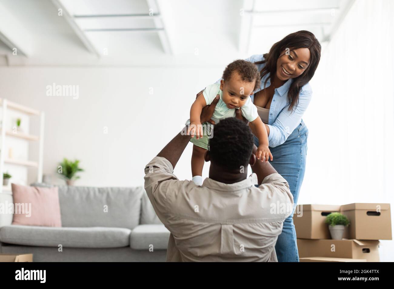 Bonne famille afro-américaine jouant dans le nouvel appartement Banque D'Images