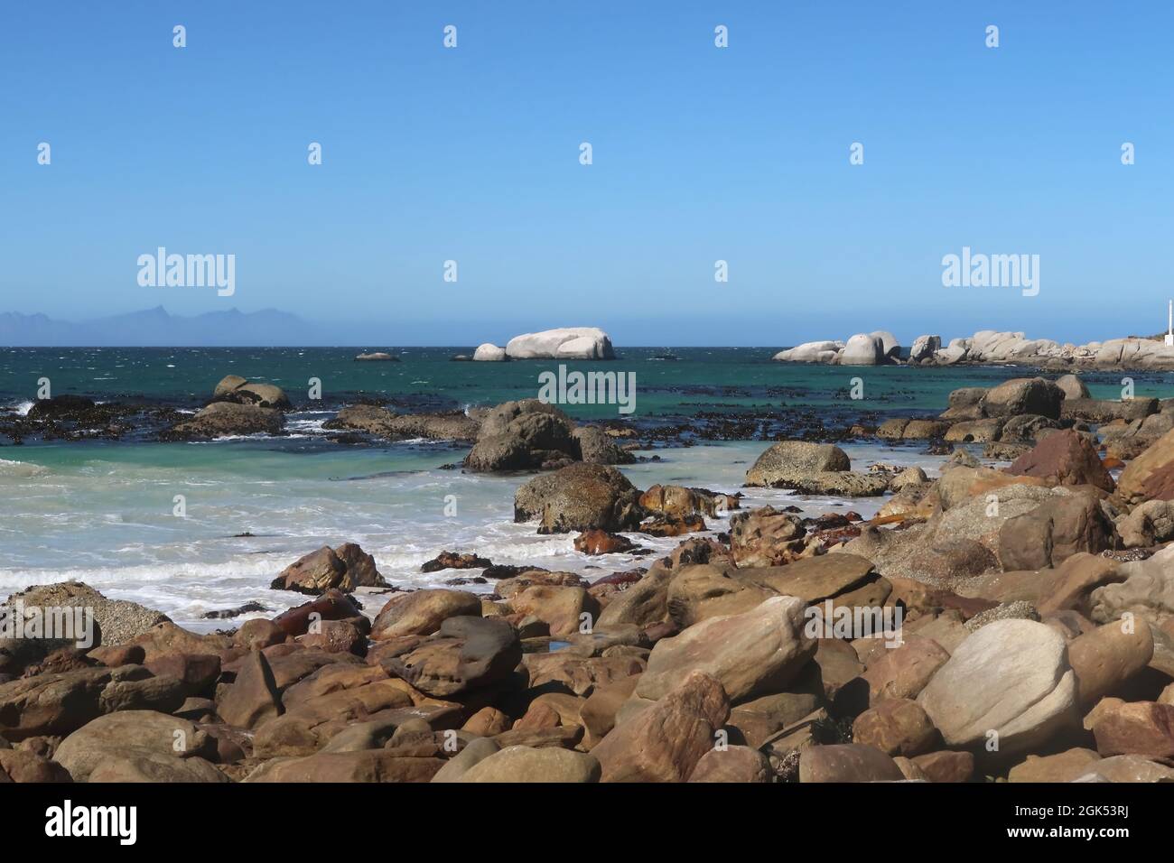 Eaux de l'océan Indien turquoise le long d'une plage de sable avec de grands blocs de granit près de la ville de Simons, sur la péninsule du Cap, le Cap, afrique du Sud Banque D'Images