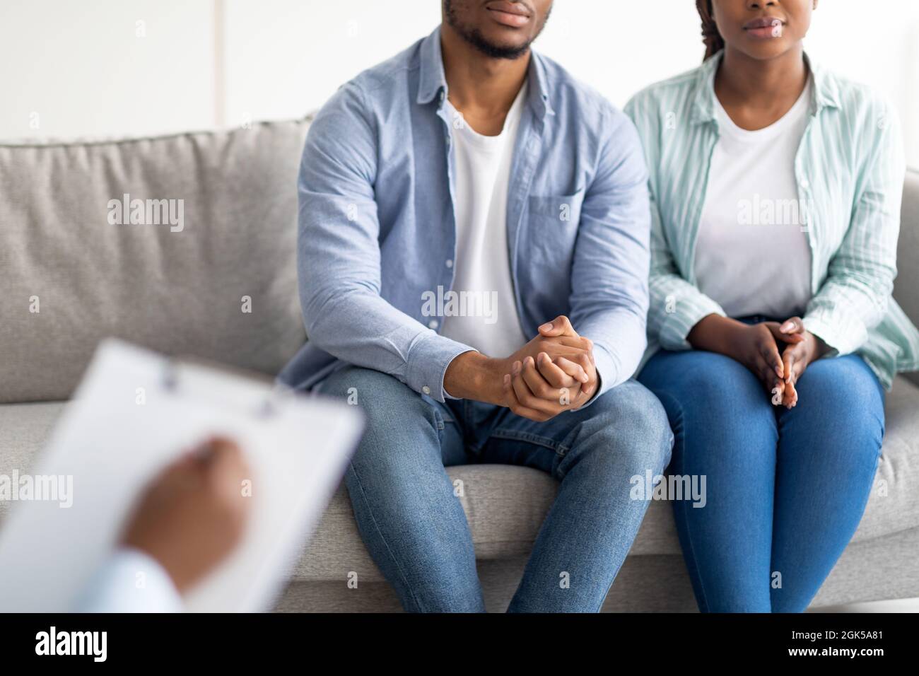 Vue rognée d'un jeune couple noir marié en consultation avec un psychologue, en cours de thérapie familiale à la clinique Banque D'Images