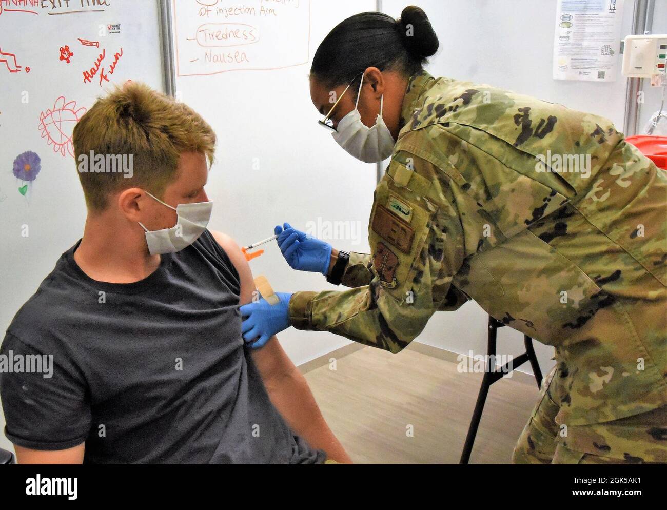 New York Air National Guard TSgt Sikinia Kemp, un medic avec la 106e escadre de sauvetage Medic, affecté à la foi-Sud, administre le 1er vaccin Pfizer à Zack Soss, 24 ans, de Roslyn, NY, au site de distribution du vaccin situé à l'Université d'État de NY à Old Westbury, LI, NY, Le 5 août 2021. Les forces militaires de l'État de New York continuent de soutenir plusieurs sites de vaccination dans l'ensemble de l'État dans le cadre des efforts en cours de l'État pour vacciner le plus grand nombre possible de New-Yorkais. Banque D'Images