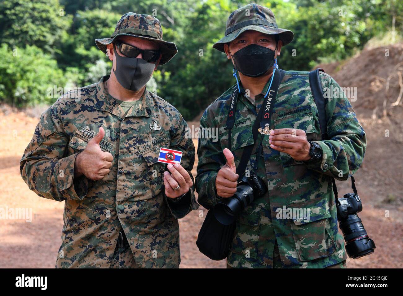 U.S. Marine corps Gunnery Sgt. Edward Chapman, à gauche, et le maître en chef du corps royal thaïlandais Phongdanai Koonkampra, photographe au Centre thaïlandais d'action contre les mines, Posez après avoir échangé un badge américain d'ordinance explosive et un timbre de la Marine royale thaïlandaise lors de l'exercice Cobra Gold 21 dans la zone d'entraînement de Ta Mor Roi dans la province de Surin, Thaïlande, le 7 août 2021. Les membres de service des deux pays échangent régulièrement des cadeaux comme symbole de l'amitié de longue date entre le peuple thaïlandais et les États-Unis. L'exercice Cobra Gold en est à sa 40e année. Pendant le co-sponsorisé ex Banque D'Images
