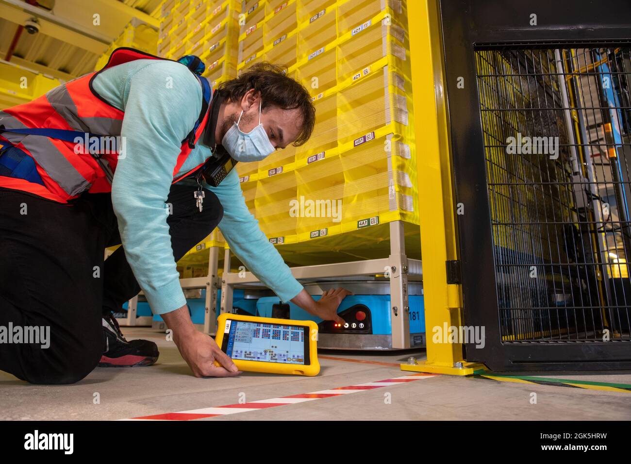 Graben, Allemagne. 13 septembre 2021. Philipp Weiß contrôle un robot logistique avec une tablette de la société Amazon. Le centre logistique du quartier d'Augsbourg a été modernisé pour 150 millions d'euros et converti pour l'exploitation de robots. Credit: Stefan Puchner/dpa/Alay Live News Banque D'Images