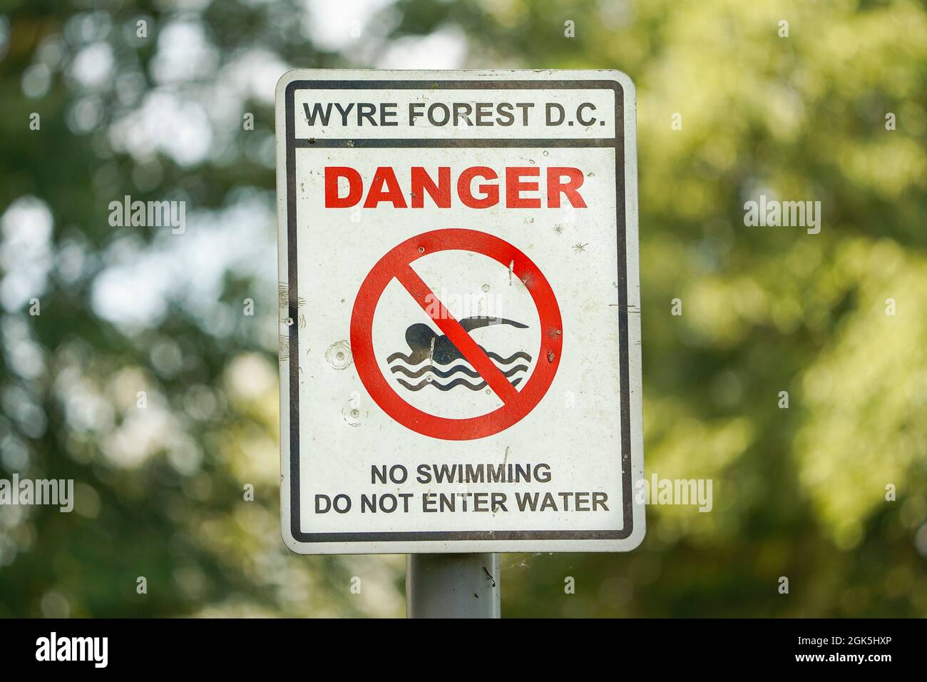Gros plan d'un avis de sécurité du conseil publié par un lac d'un parc public britannique décrivant le risque pour le public d'entrer en eau libre : "Danger, ne pas nager, ne pas entrer dans l'eau". Banque D'Images