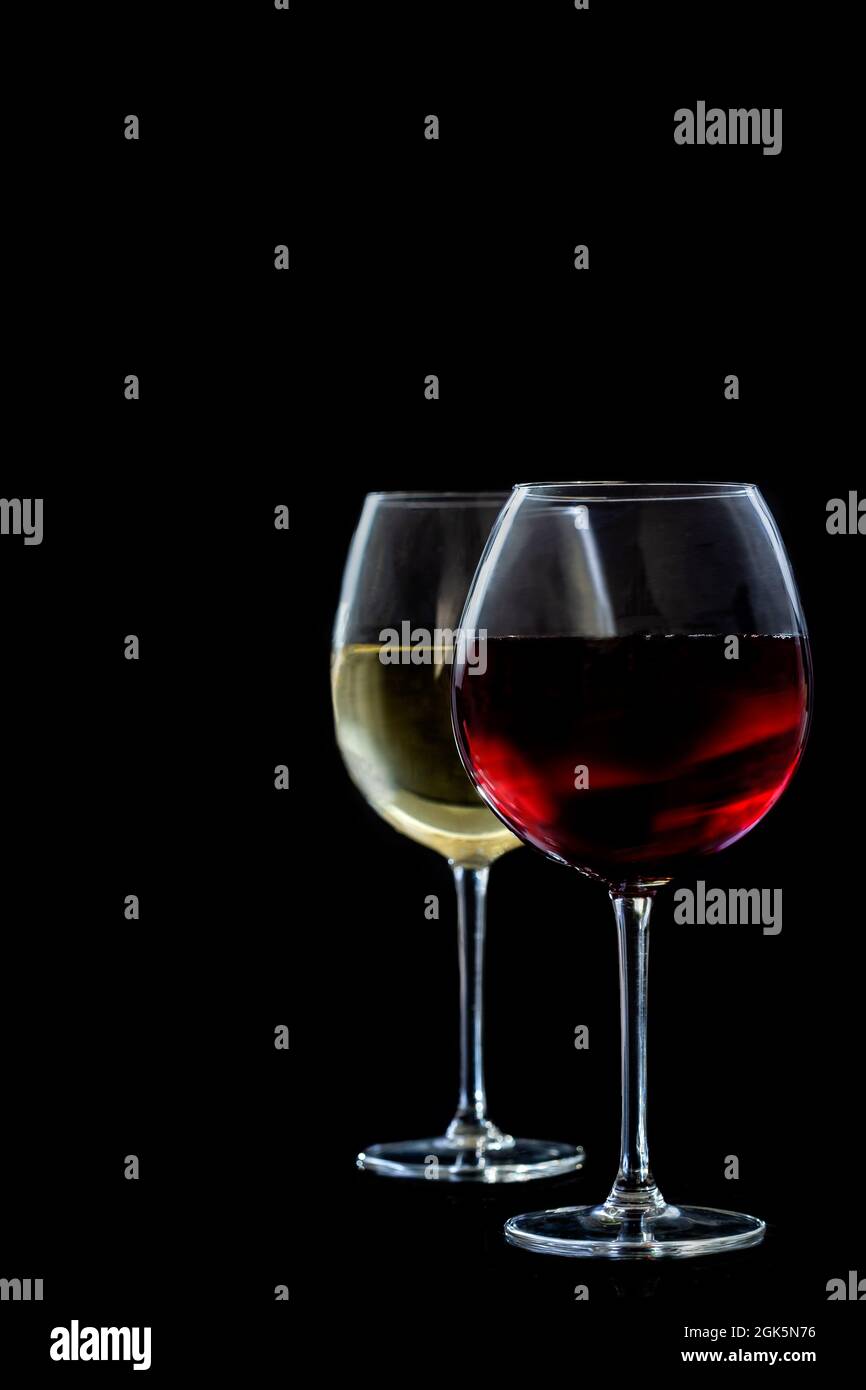 Deux verres de vin rouge et blanc sur fond noir. Banque D'Images