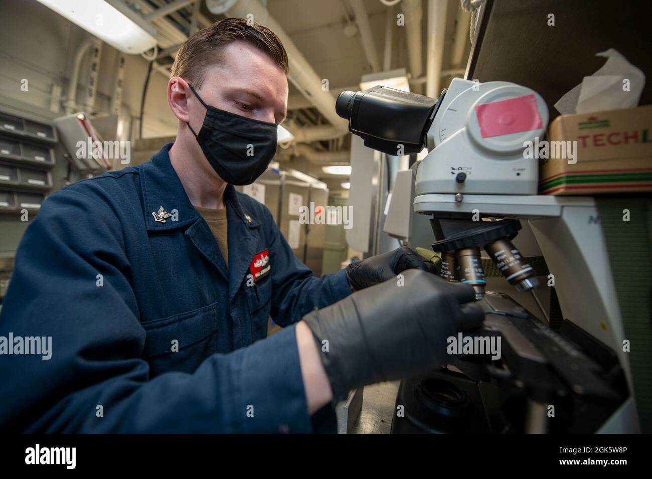 210810-N-IG124-1010 OCÉAN ATLANTIQUE (AOÛT 10, 2021) Hospital Corpsman 2e classe Jordan Busby, d'Austin, Texas, utilise un microscope pour observer un échantillon d'analyse d'urine dans un bureau médical à bord du porte-avions USS Harry S. Truman de la classe Nimitz (CVN 75). Truman mène une formation sur la préparation à l'état de préparation dans l'océan Atlantique en vue des opérations futures. Banque D'Images