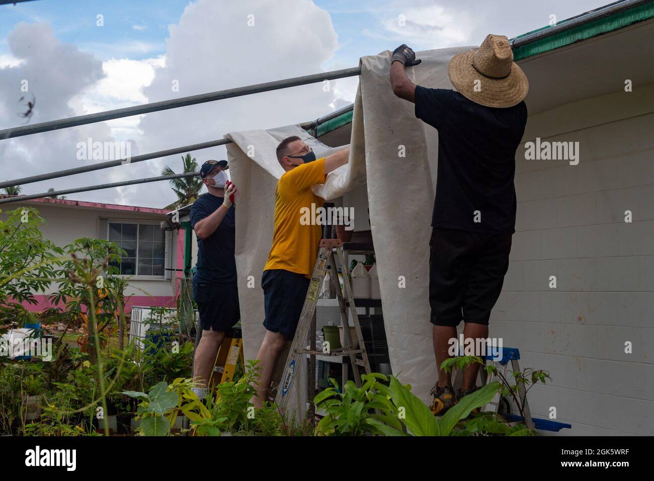 DEDEDEDO, Guam (août 9, 2021) des marins affectés au navire d'assaut amphibie déployé à l'avant USS America (LHA 6) ont mis en place une bâche pour couvrir une pépinière de légumes avec un local, lors d'un événement de bénévolat avec Island Girl Power, une organisation à but non lucratif qui offre des programmes de prévention et d'enrichissement aux jeunes filles et aux adolescents dans un environnement sûr, stimulant et positif. L'Amérique, vaisseau amiral de l'America Expeditionary Strike Group, ainsi que la 31e Marine Expeditionary Unit, opère dans la zone de responsabilité de la 7e flotte des États-Unis pour améliorer l'interopérabilité avec les alliés et les partenaires et Banque D'Images