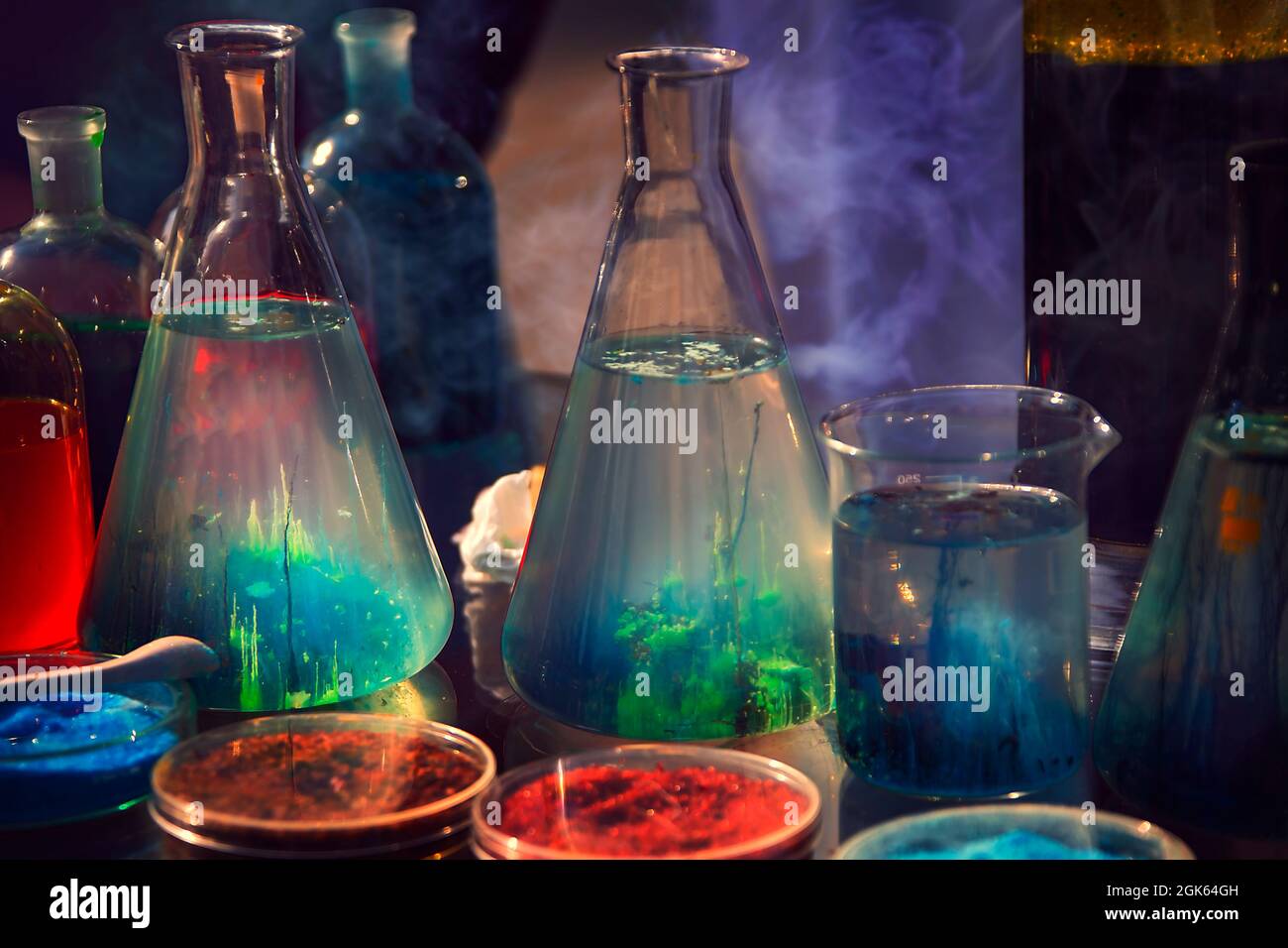 Laboratoires de biologie. Plantes vertes en bouteilles de verre sur fond sombre. Dans des flacons, milieu pour bactéries. Laboratoire mystique. Banque D'Images