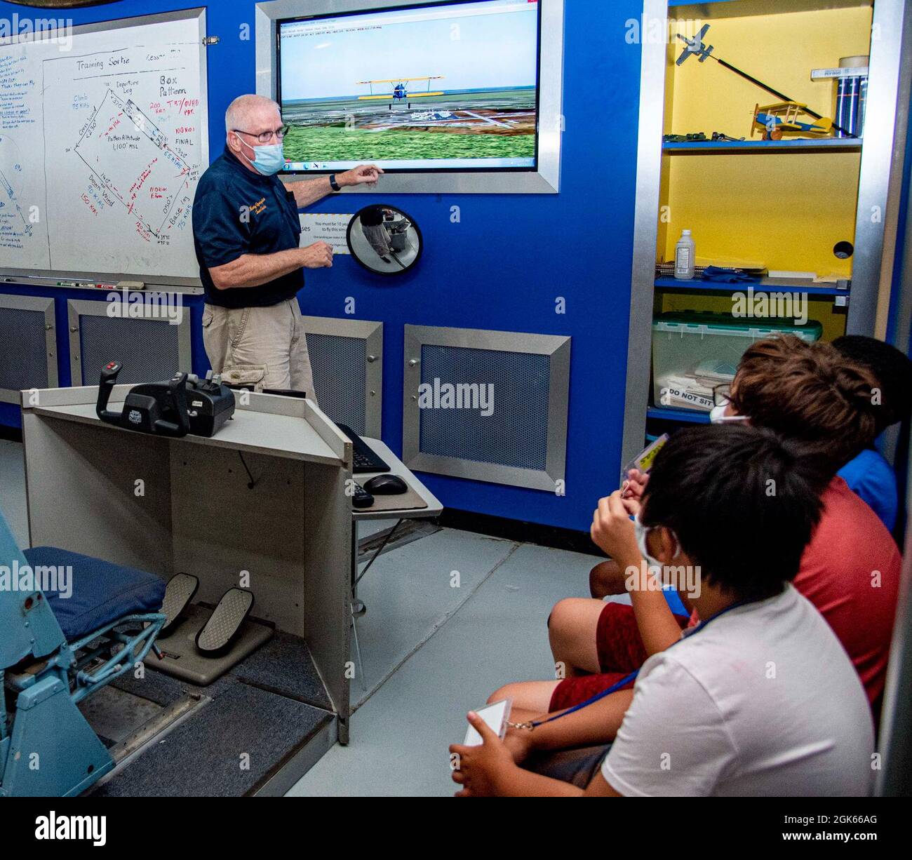 John Martin, bénévole du Air Mobility Command Museum, explique aux participants du camp d'aviation d'été comment le simulateur de vol fonctionne au Musée AMC, sur la base aérienne de Douvres, Delaware, le 10 août 2021. Les participants ont eu l'occasion de voler un avion Staarman simulé, de voler dans un Cessna avec le Dover AFB Aero Club, d'interroger des aviateurs et des retraités et d'en apprendre plus sur l'armée. Le camp d’été de cette année a utilisé des salles de classe Quonset Hut créées au cours de la pandémie de l’an dernier et peut également être utilisé par des parents à domicile. Banque D'Images John Martin, bénévole du Air Mobility Command Museum, explique aux participants du camp d'aviation d'été comment le simulateur de vol fonctionne au Musée AMC, sur la base aérienne de Douvres, Delaware, le 10 août 2021. Les participants ont eu l'occasion de voler un avion Staarman simulé, de voler dans un Cessna avec le Dover AFB Aero Club, d'interroger des aviateurs et des retraités et d'en apprendre plus sur l'armée. Le camp d’été de cette année a utilisé des salles de classe Quonset Hut créées au cours de la pandémie de l’an dernier et peut également être utilisé par des parents à domicile. Banque D'Images