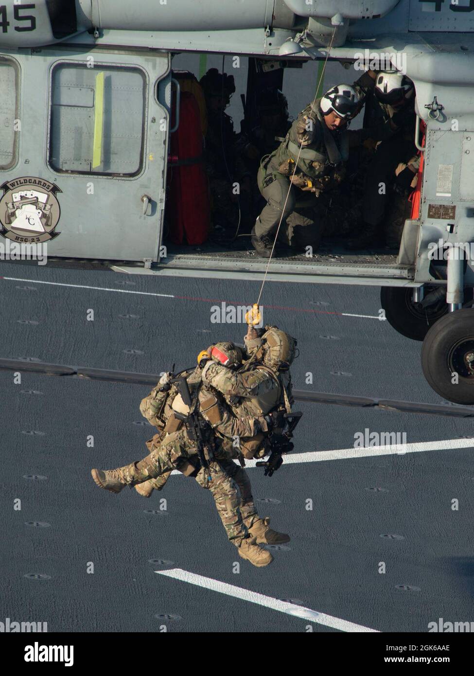 210813-N-WY048-1240 OCÉAN PACIFIQUE (AOÛT 13, 2021) – membres de l'équipe d'intervention de la sécurité maritime de la Garde côtière, à bord d'un buse de mer MH-60S, affecté à l'Escadron de combat en mer (HSC) 23, à la base maritime expéditionnaire USS Miguel Keith (ESB 5), août 13. HSC 23 est embarqué à bord de Miguel Keith, qui effectue des opérations de routine dans la 3e flotte des États-Unis. Banque D'Images