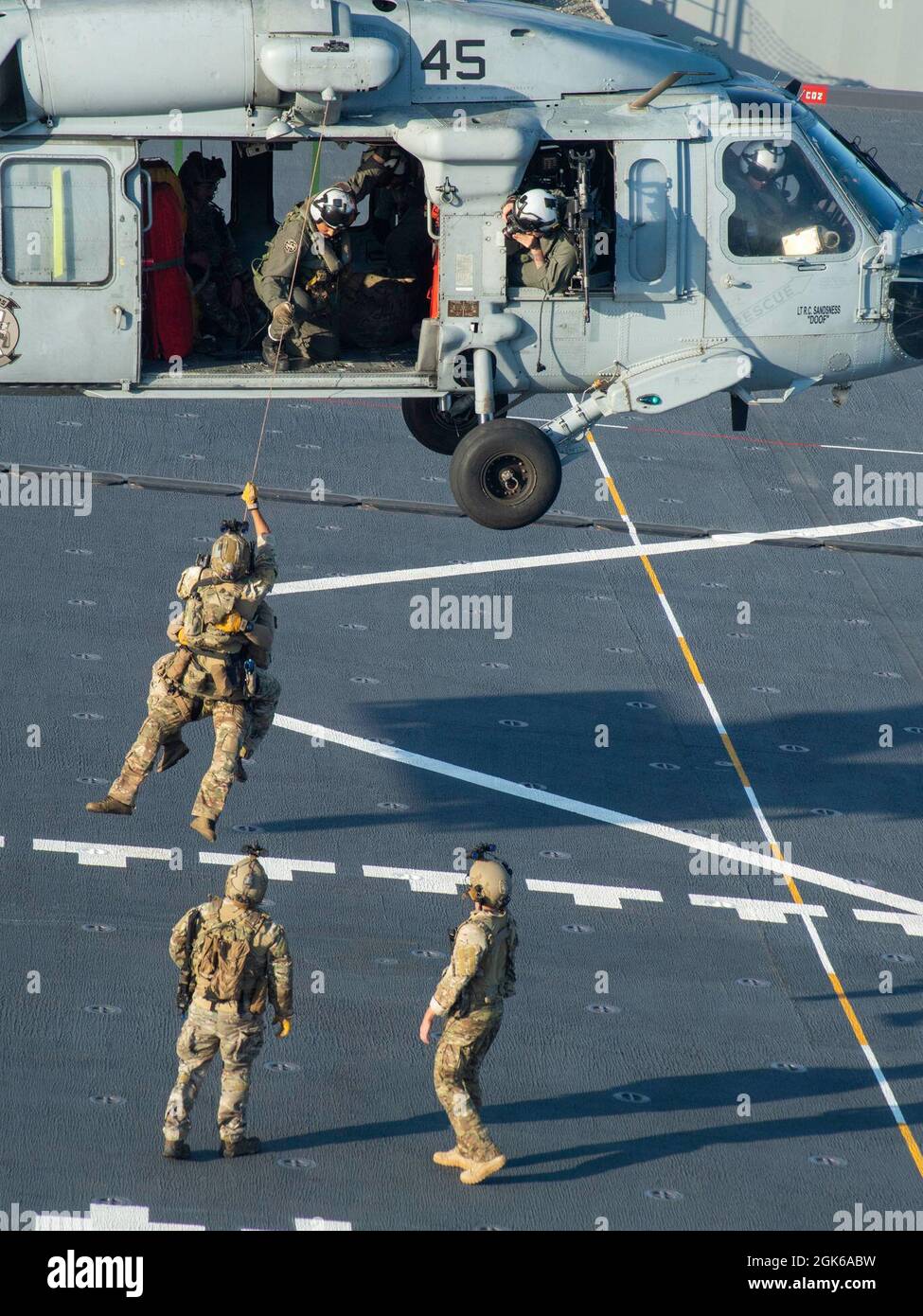 210813-N-WY048-1220 OCÉAN PACIFIQUE (AOÛT 13, 2021) – membres de l'équipe d'intervention de la sécurité maritime de la Garde côtière, à bord d'un buse de mer MH-60S, affecté à l'Escadron de combat en mer (HSC) 23, à la base maritime expéditionnaire USS Miguel Keith (ESB 5), août 13. HSC 23 est embarqué à bord de Miguel Keith, qui effectue des opérations de routine dans la 3e flotte des États-Unis. Banque D'Images