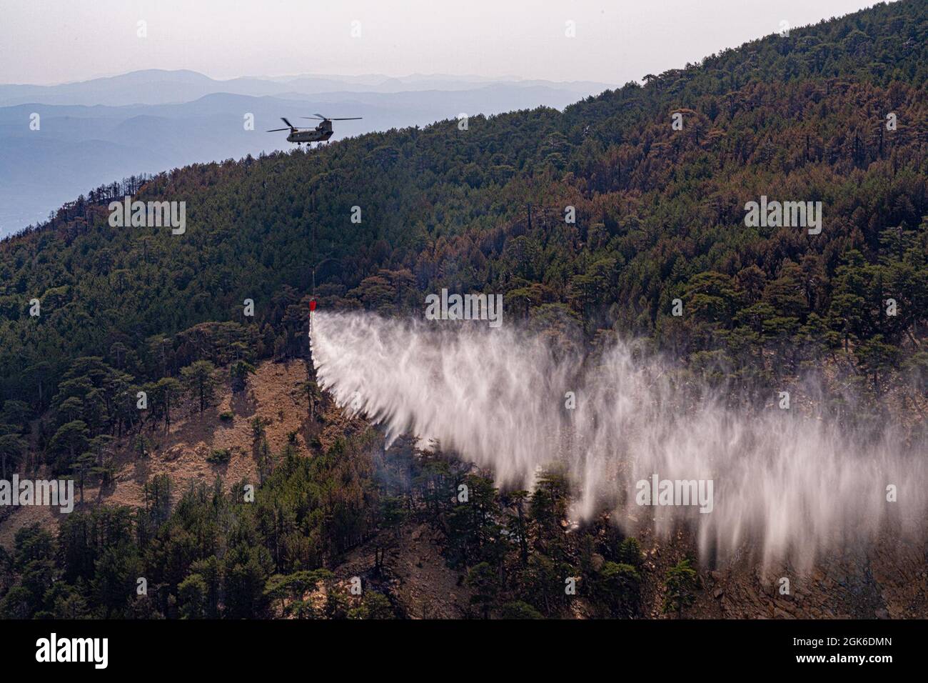 Les équipages de l'armée américaine affectés au 1er Bataillon, 214e Régiment d'aviation, 12e Brigade de l'aviation de combat, tombent de l'eau au-dessus d'un incendie dans l'ouest de la Turquie, le 14 août 2021. Les équipes remplissent les seaux d'eau des lacs voisins et des piscines artificielles plus petites spécialement créées pour soutenir les efforts de lutte contre les incendies aériens dans la région. Banque D'Images
