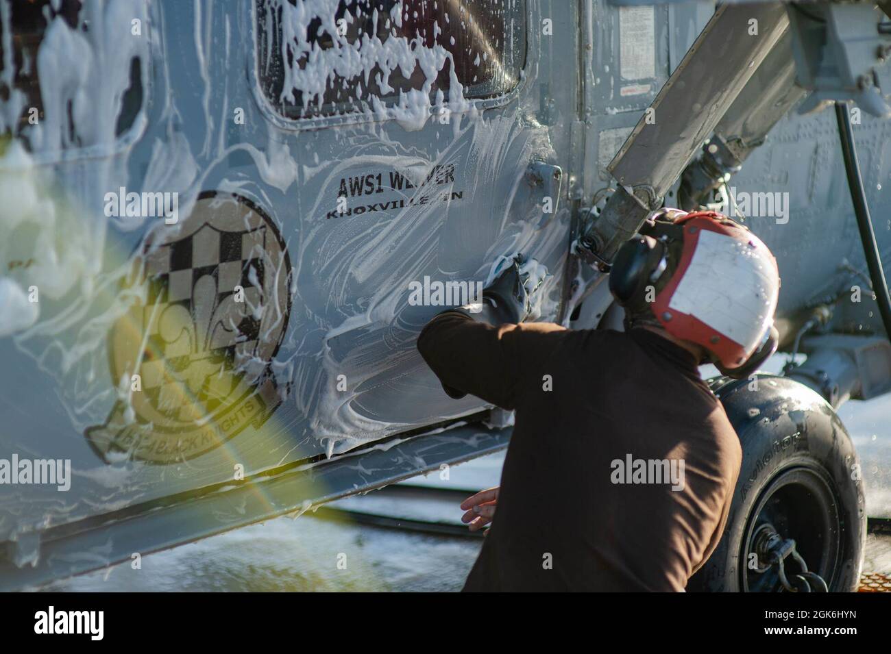 210816-N-TY704-2233 OCÉAN PACIFIQUE (le 16 août 2021) Airman, mécanicien de structures aéronautiques, apprenti Chaz Segress, originaire d'Oklahoma City, nettoie un Hawk de mer MH-60S affecté aux « Chevaliers noirs » de l'Escadron de combat en mer (HSC) 4, sur le pont de vol du porte-avions de classe Nimitz USS Carl Vinson (CVN 70), le 16 août, 2021. Le Groupe de grève des transporteurs Carl Vinson (VINCSG), dirigé par le Groupe de grève des transporteurs (CSG) 1, est actuellement déployé à l'appui des opérations mondiales de sécurité maritime. Banque D'Images