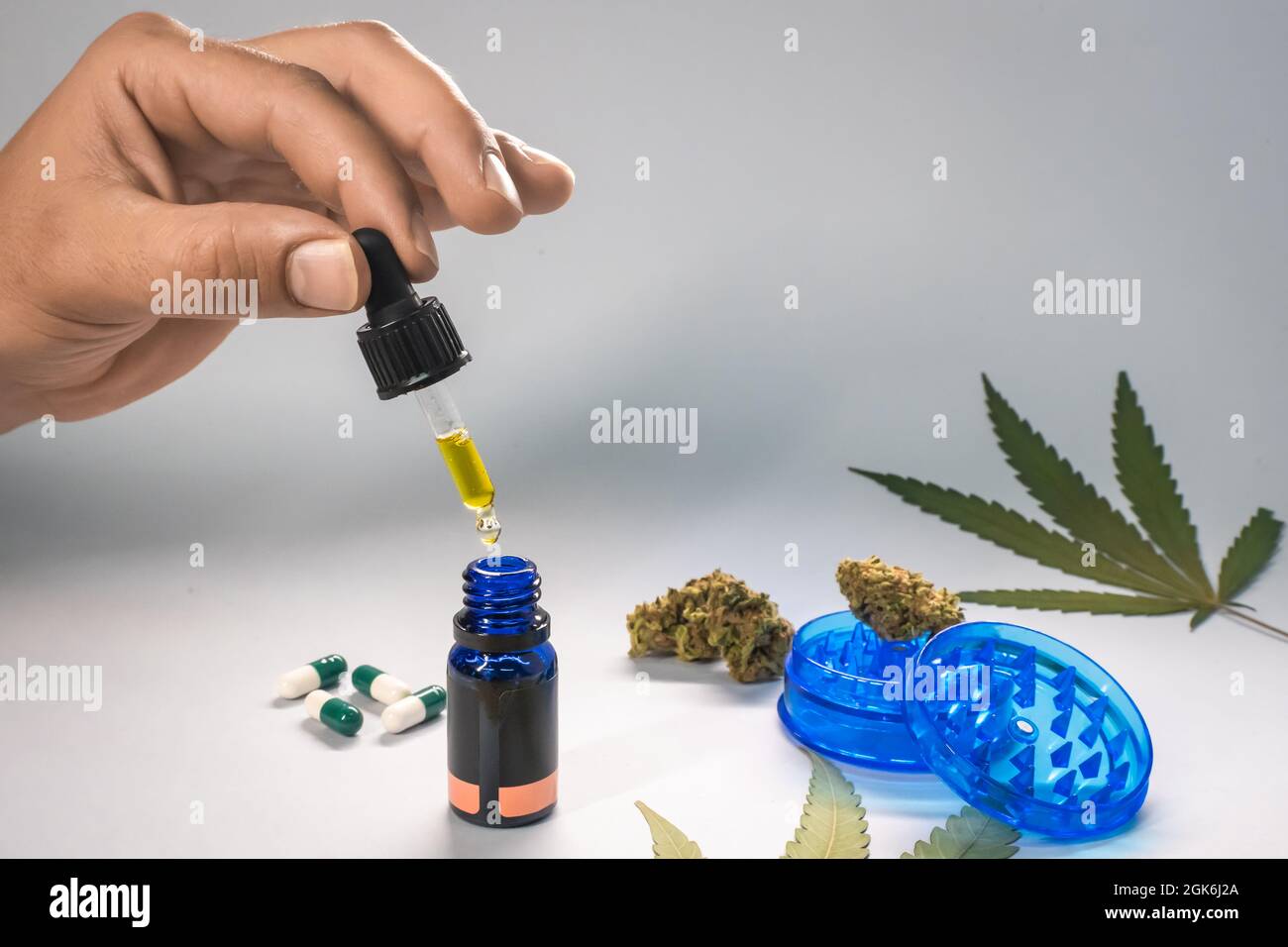 Mains de l'huile de CBD, des capsules et des bourgeons de chanvre sur fond blanc.Produits cosmétiques et de beauté biologiques et naturels à base de chanvre.Concept de cannabis médical. Banque D'Images