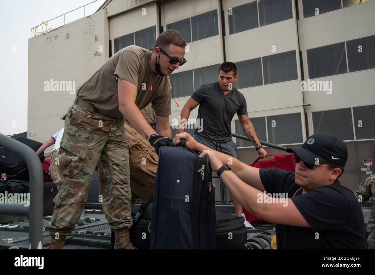 Le premier Airman de la U.S. Air Force Jay Rhodes, spécialiste du transport aérien du 366e Escadron de préparation logistique, passe un sac de voyage à un Airman récemment déployé à la base aérienne de Mountain Home, Idaho, le 16 août 2021. Le 366e LRS joue un rôle important dans les questions de déploiement. Ils traitent des fonctions de déploiement du fret ainsi que de la planification et de l'acquisition d'aéronefs. Ensuite, ils facilitent le chargement et le déchargement de la cargaison et des pax. Banque D'Images