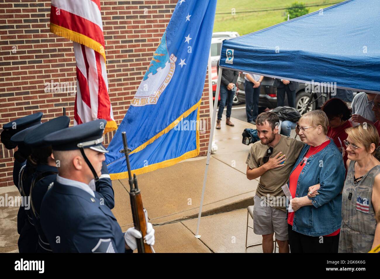 Membres de la famille de Fallen Airman, Sgt. Dylan Elchin, se lever pendant le chant de l'hymne national et la présentation des couleurs par la 911e Garde d'honneur de l'aile Airlift lors d'une cérémonie de dédicace qui renomme le bureau de poste à Hookstown, Pennsylvanie, le 16 août 2021. Le bureau de poste a été renommé après le sergent d'état-major. Dylan Elchin qui a été tué par une bombe au bord de la route dans la province afghane de Ghazni en novembre 2018. Banque D'Images